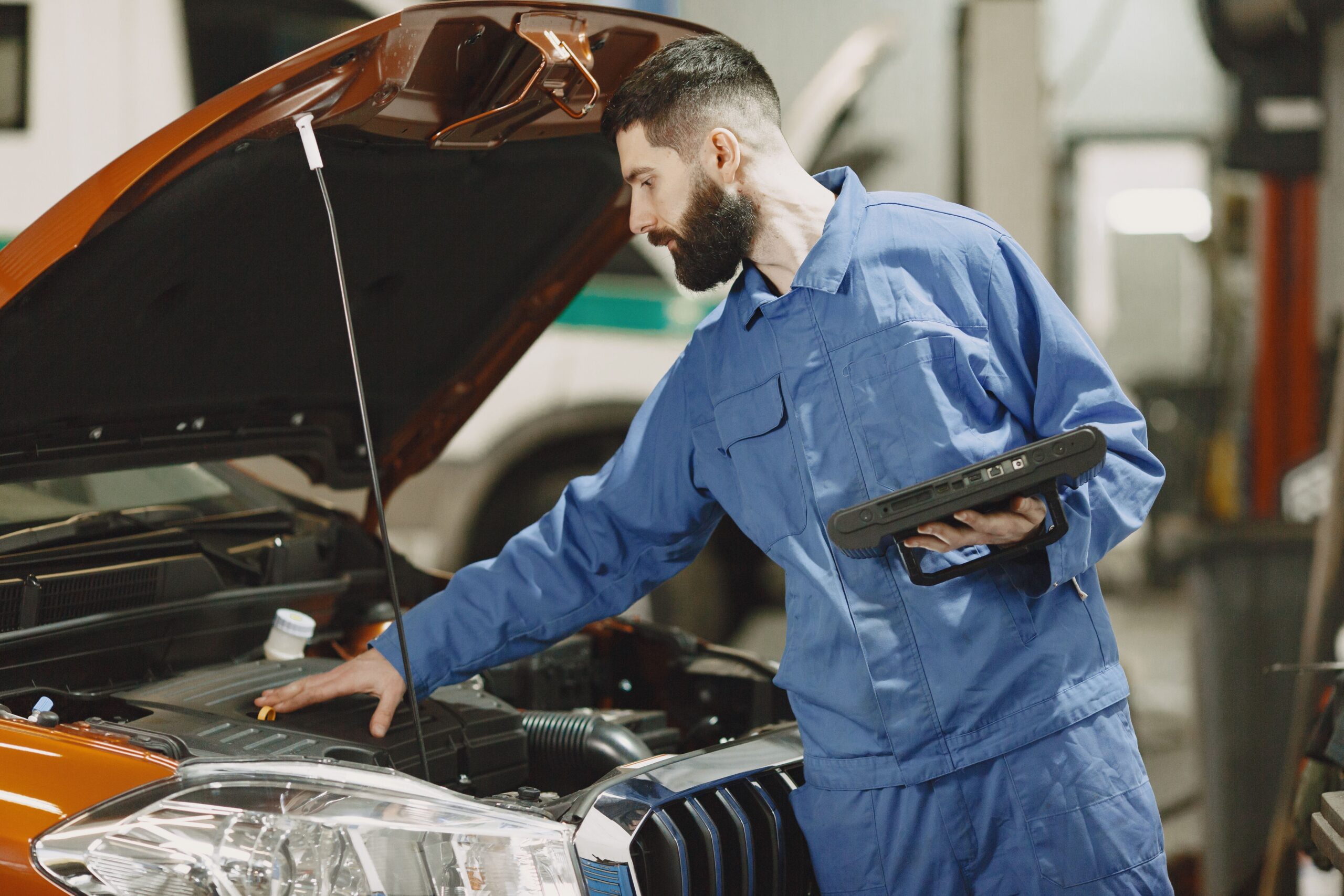 Mechanic checking fluid levels under the hood of a car
