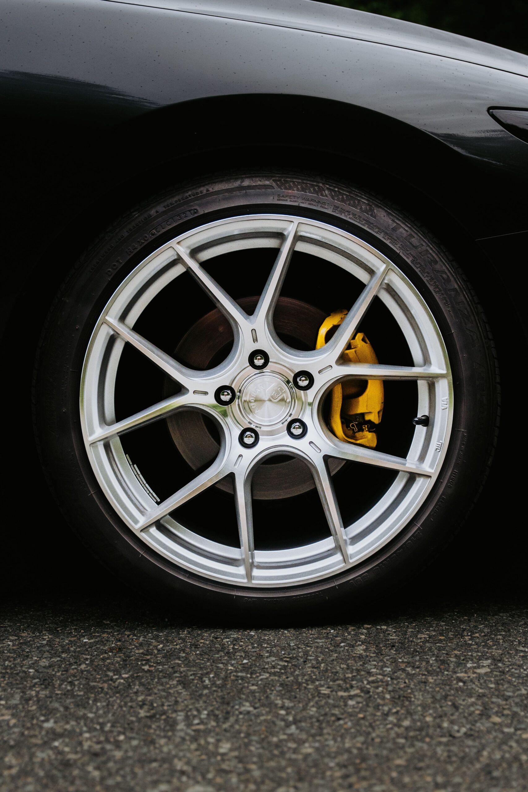 Close-up of a sports car wheel with a yellow brake caliper