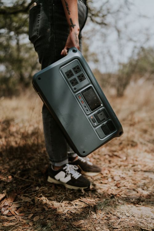 Person carrying a portable power station outdoors, representing the best portable power stations 2026