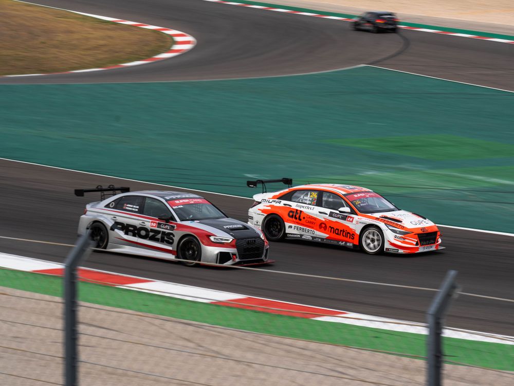 Two cars at speed on a road course during a track day checklist-prepped HPDE event