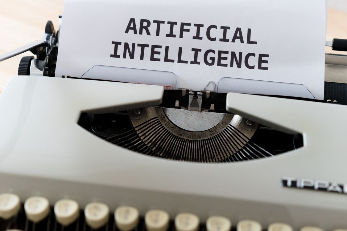 Typewriter with a sheet reading ARTIFICIAL INTELLIGENCE, symbolizing AI watermarking of generated text