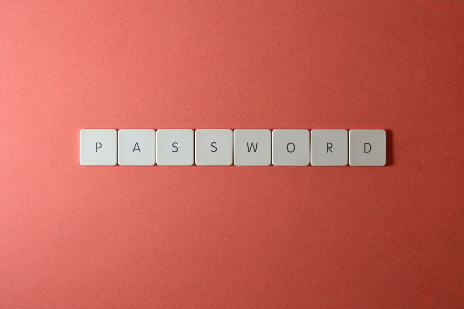 Keyboard tiles spelling PASSWORD, representing the 1Password vs Bitwarden comparison